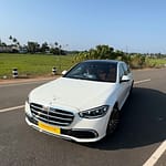 A white Mercedes-Benz decorated with white roses for a wedding in Kochi.